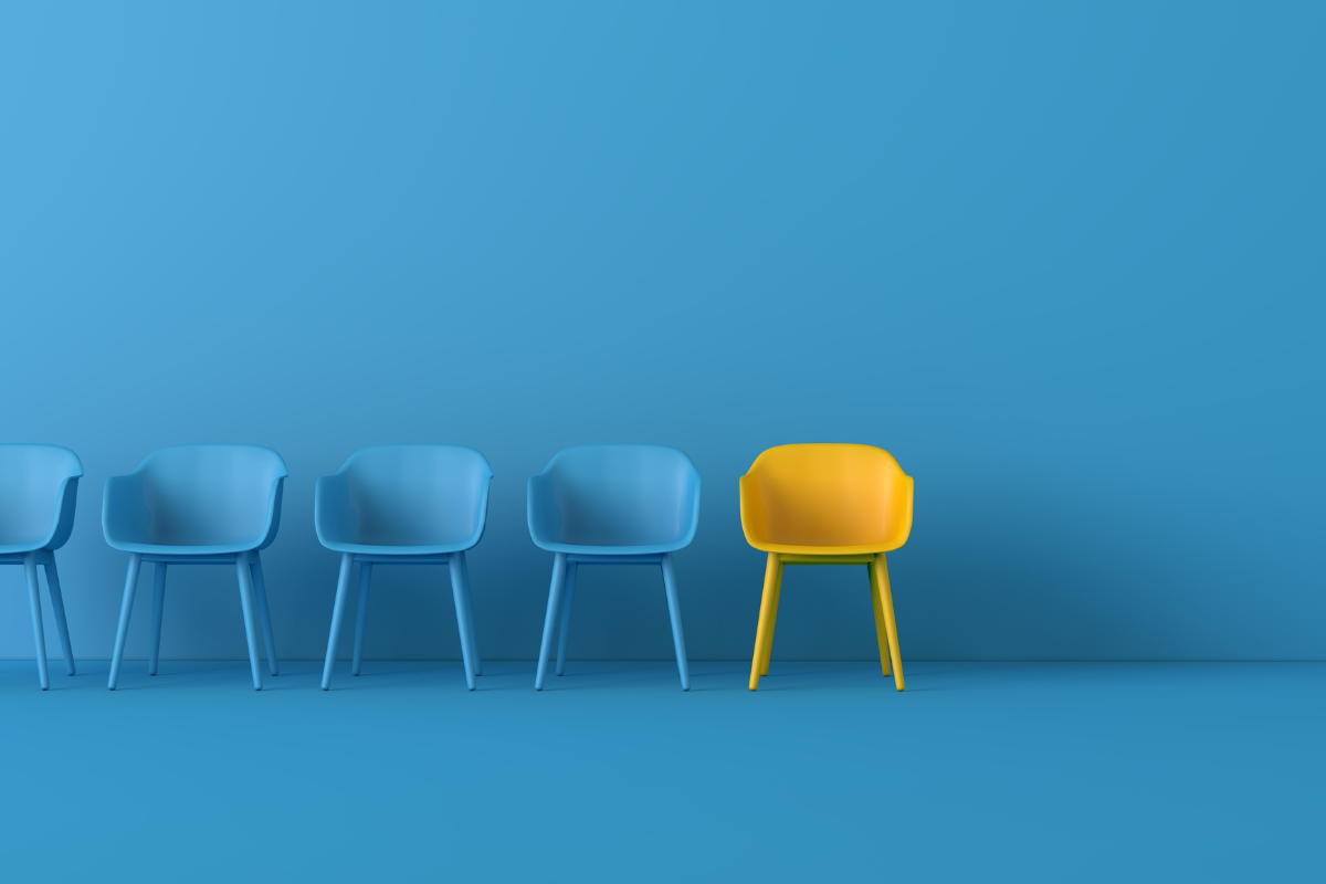 a blue room with four blue chairs up against a wall and one yellow chair that stands out visually from the rest